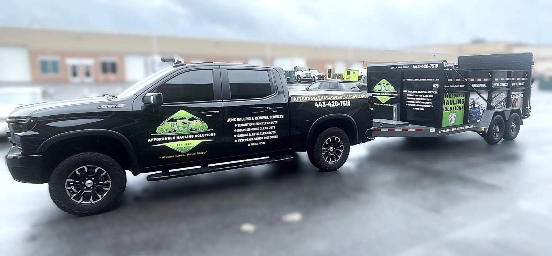image5 Black truck with branded trailer on road.